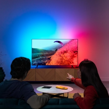 A couple enjoying LED light for TV with colors synced to the screen.